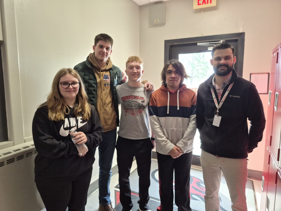 iJAG students giving their donations to Mr. Sam Pedersen