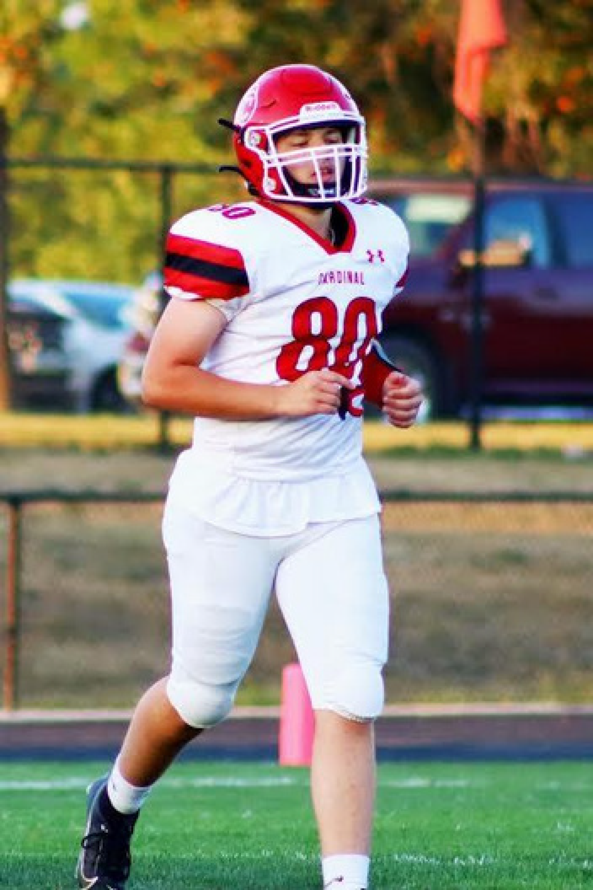 male student football player running on football field