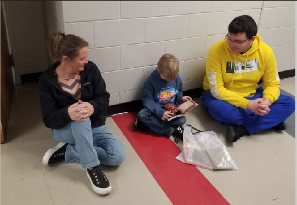 Cardinal iJAG student Hunter Sertterh reading to an elementary student.