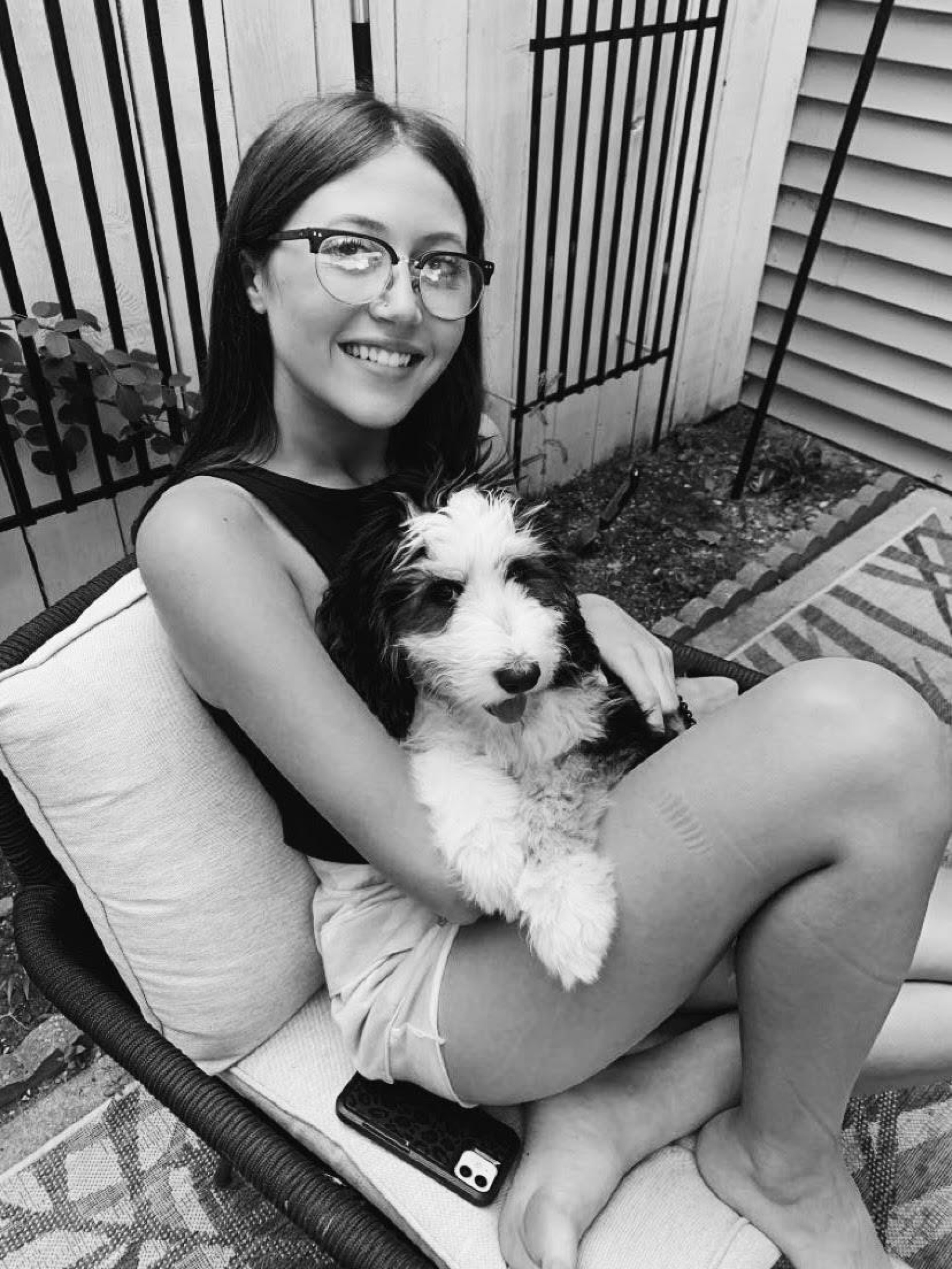 Female student sitting on a lawn chair holding a dog