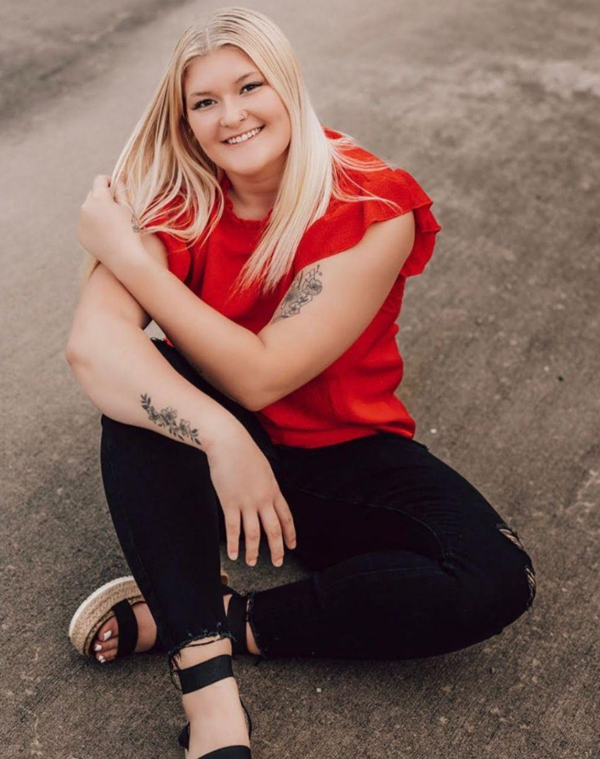 Female posing while sitting on concrete