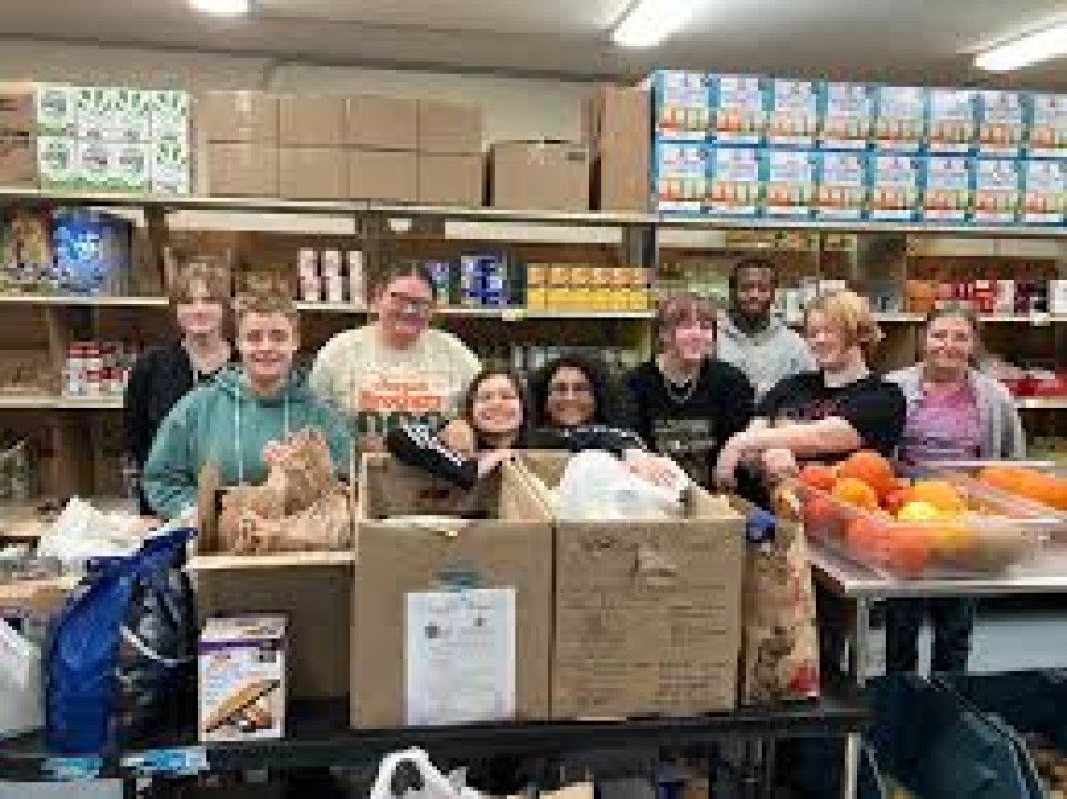 Students standing with donations at the National Honor Society Food Pantry.